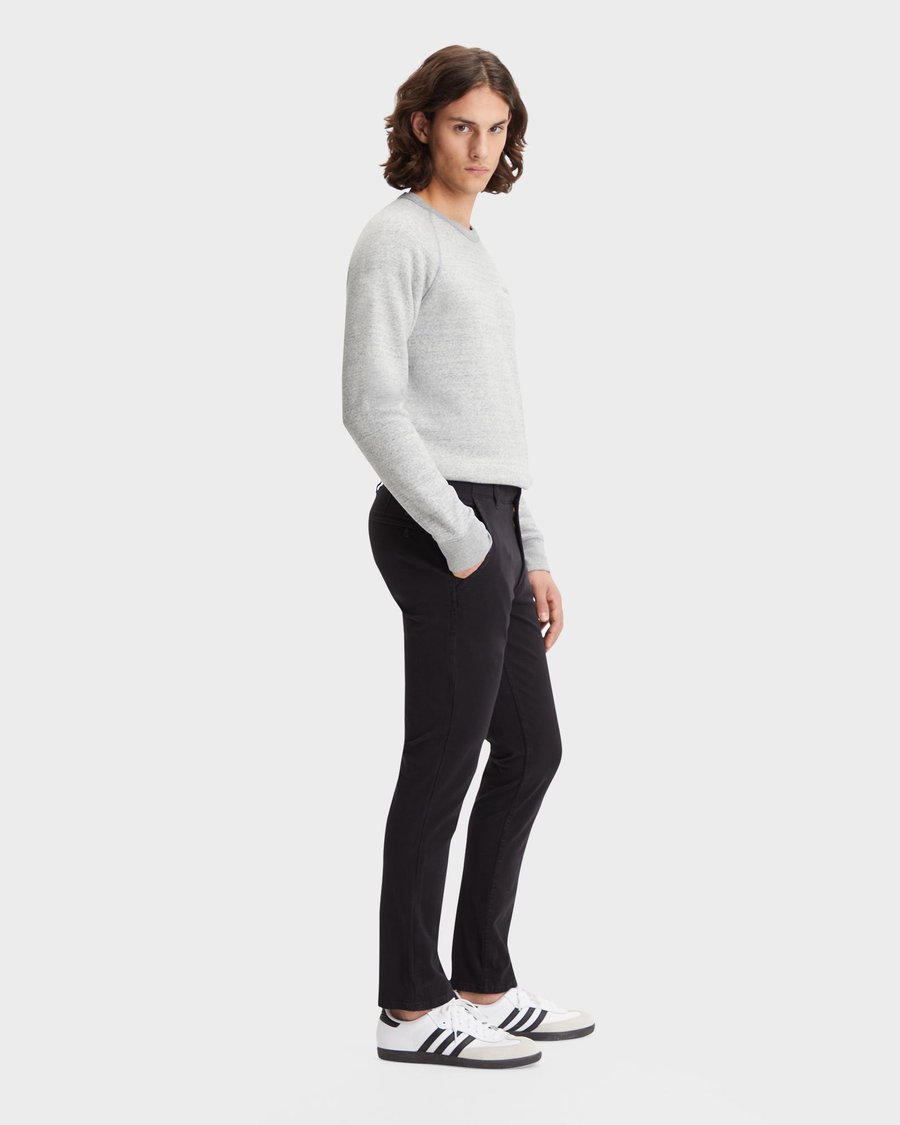 Side view of model wearing Black Men's Skinny Fit Smart 360 Flex Alpha Khaki Pants.
