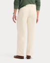 Back view of model wearing Buttercream Eighty-Six Original Pleated Chinos, Loose Fit.