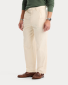 Side view of model wearing Buttercream Eighty-Six Original Pleated Chinos, Loose Fit.