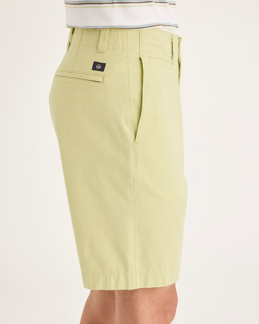 Side view of model wearing Dusty Yellow Alpha Chino Shorts, Straight Fit.