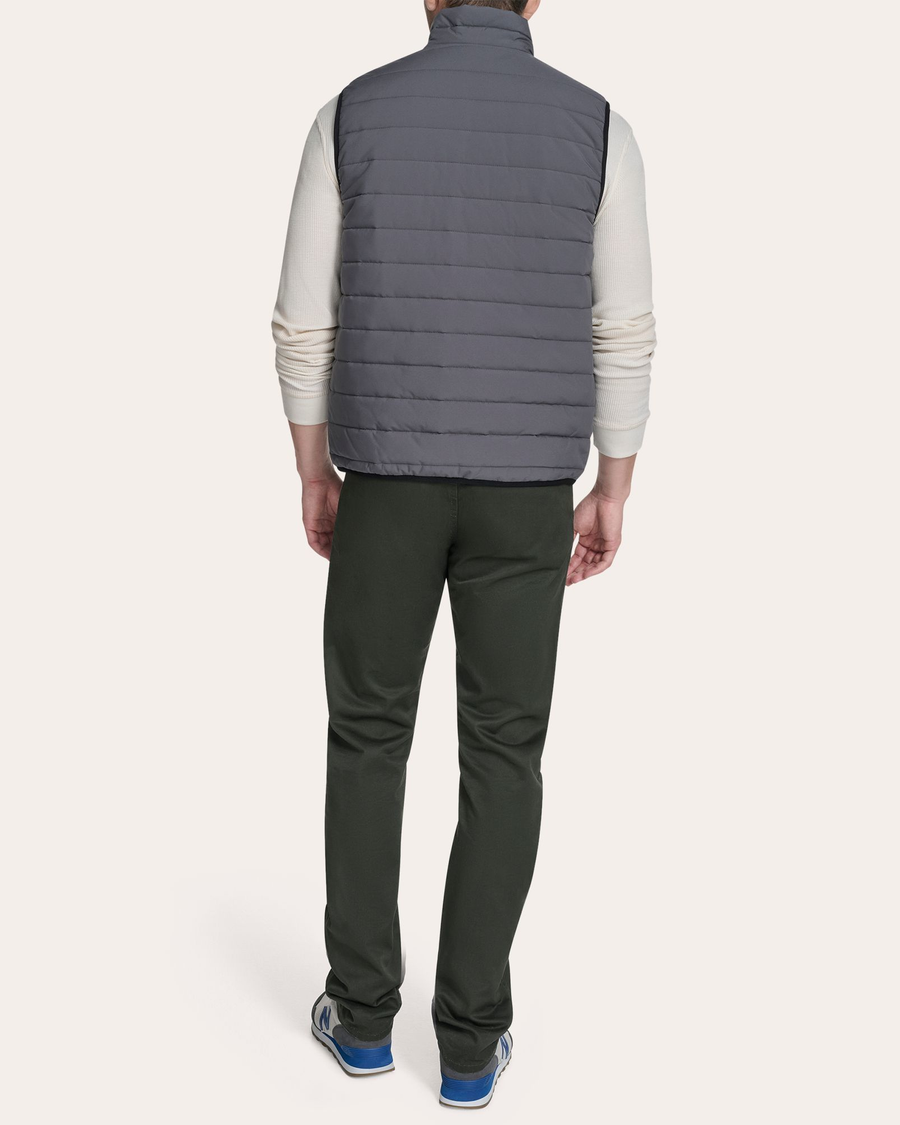 View of model wearing Grit Reversible Puffer Vest.