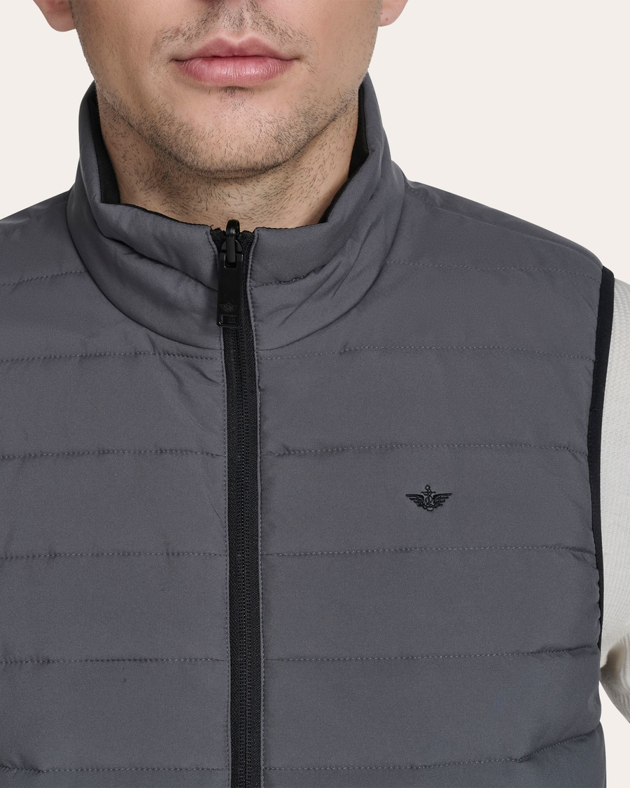 View of model wearing Grit Reversible Puffer Vest.