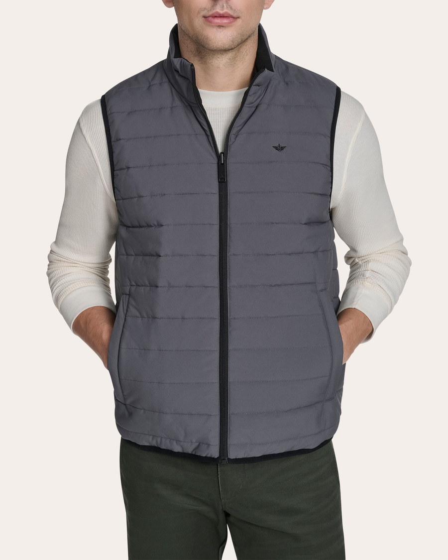 Back view of model wearing Grit Reversible Puffer Vest.