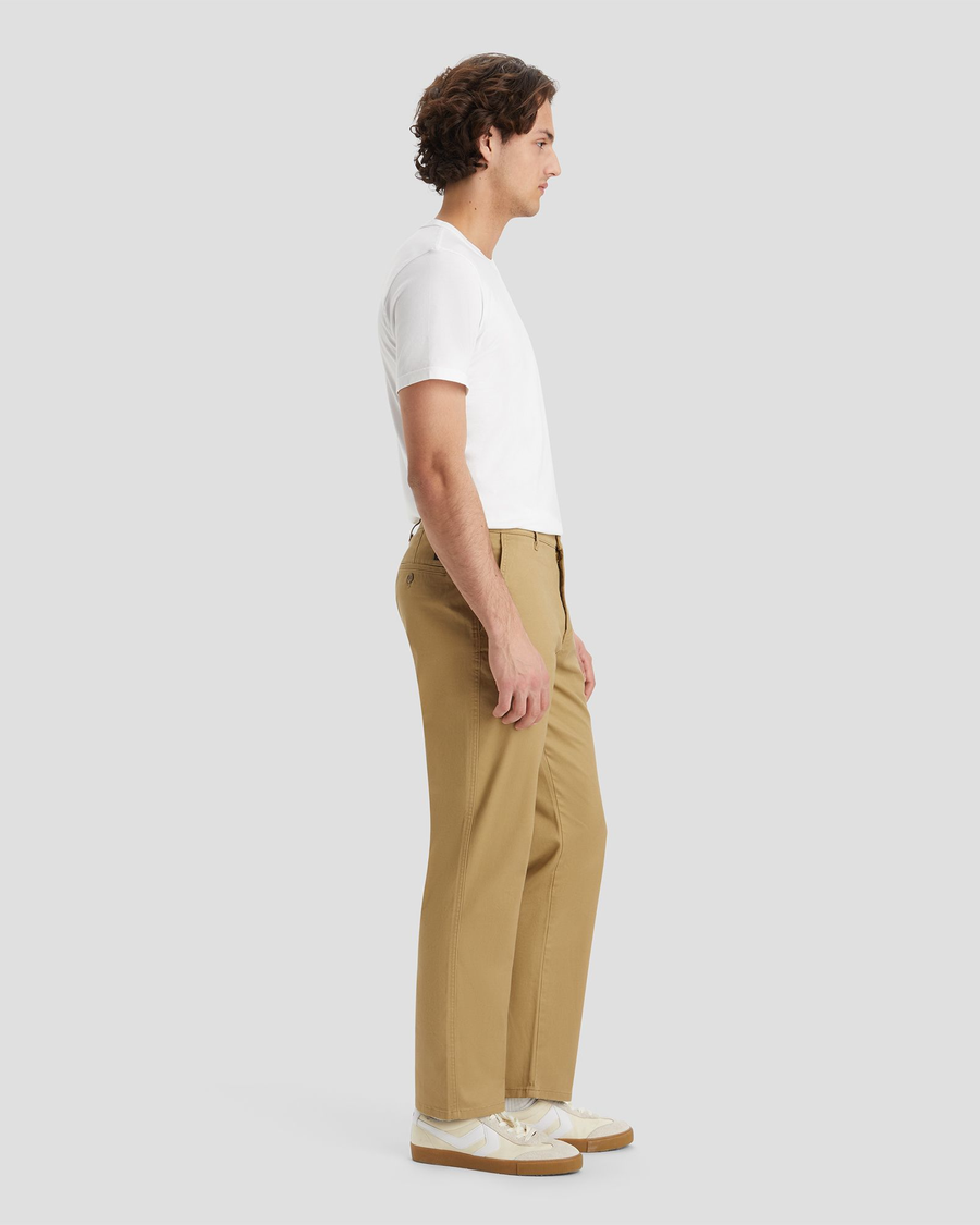 Side view of model wearing Harvest Gold Men's Straight Fit Original Chino Pants.