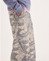 Side view of model wearing Ichabod Buttercream Eighty-Six Utility Pants, Loose Fit.