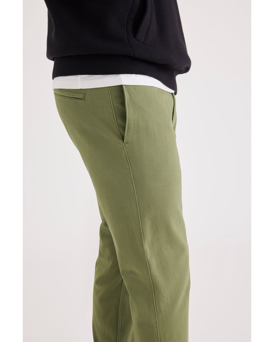 Side view of model wearing Loden Green Men's Skinny Fit Smart 360 Flex California Chino Pants.