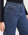 View of model wearing Medium Indigo Stonewash Women's Relaxed Fit Mid-Rise Jeans.