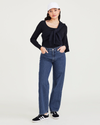 View of model wearing Medium Indigo Stonewash Women's Relaxed Fit Mid-Rise Jeans.