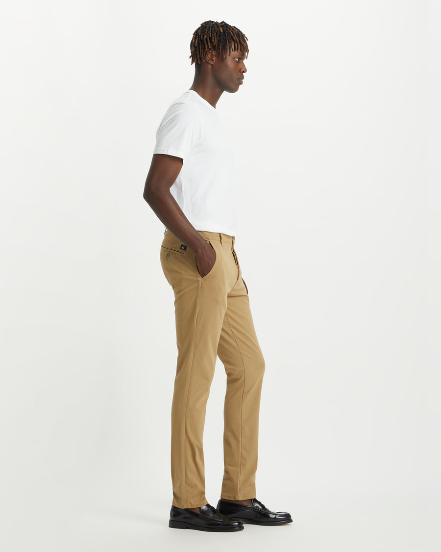 Side view of model wearing New British Khaki Men's Skinny Fit Supreme Flex Alpha Khaki Pants.