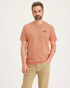 Front view of model wearing Peach Blossom Men's Slim Fit Logo Tee.