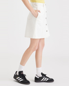 Side view of model wearing White Garment Dye Women's Button Front Mini Skirt.