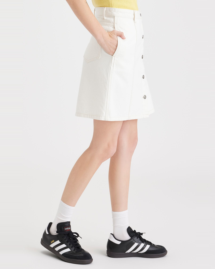 Side view of model wearing White Garment Dye Women's Button Front Mini Skirt.